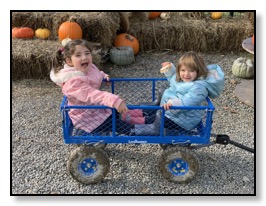 Leandra and Auriane at the pumpkin patch in a cart